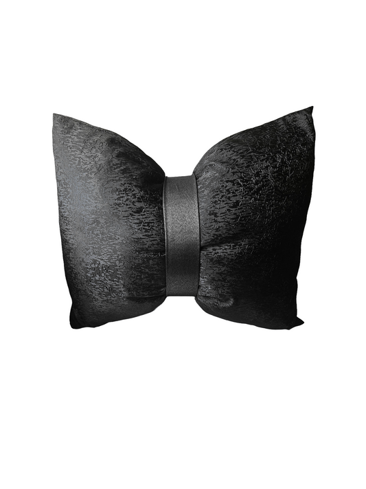 Black textured bow-shaped pillow on a white background