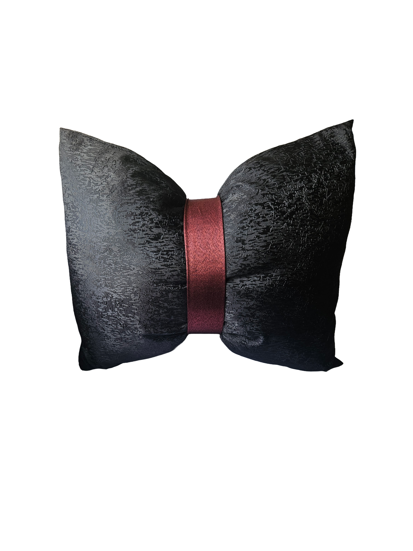 Black textured bow-shaped pillow with a red ribbon on a white background