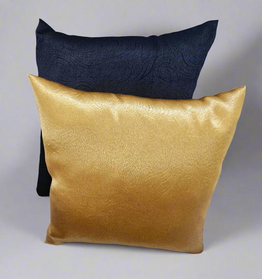 Two pillows, one navy and one gold, on a white background