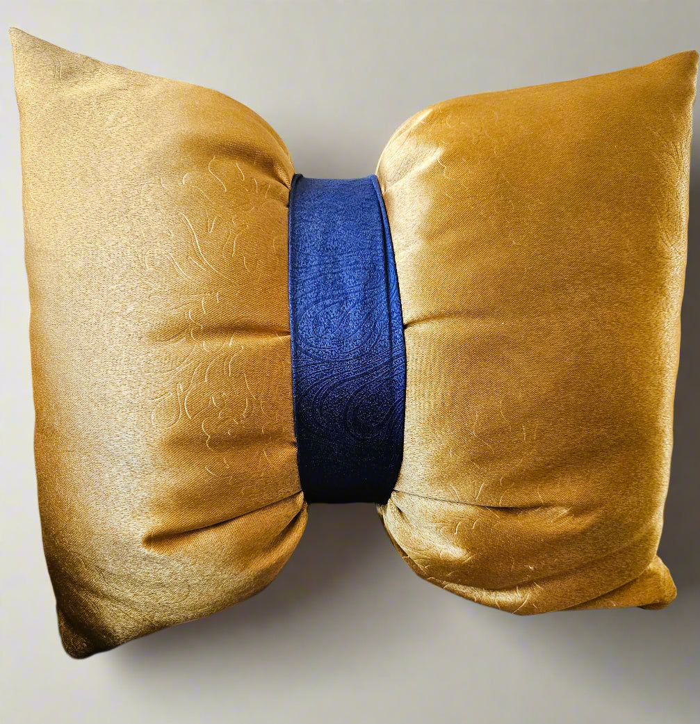 Gold pillow with a blue center cushion on a sofa.