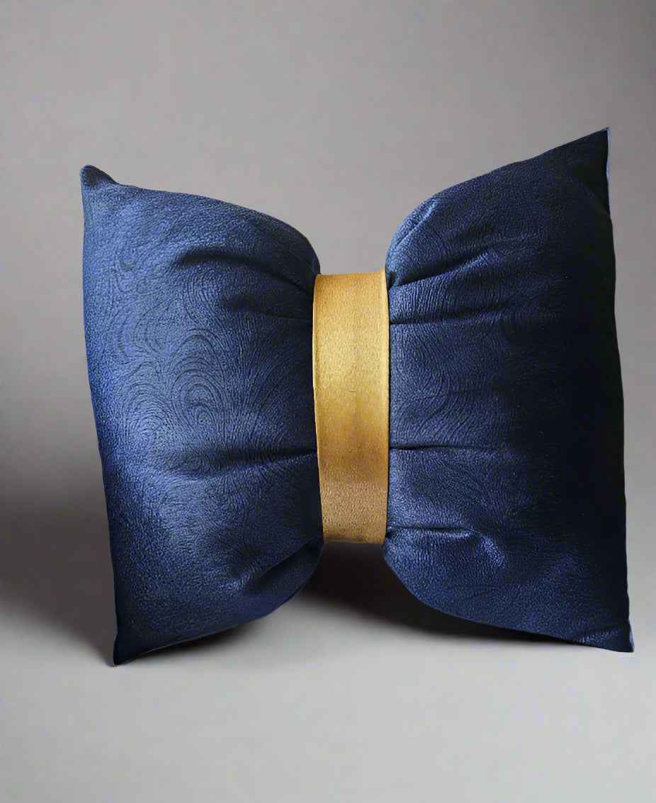 Navy blue decorative pillow with a gold center on a beige sofa.