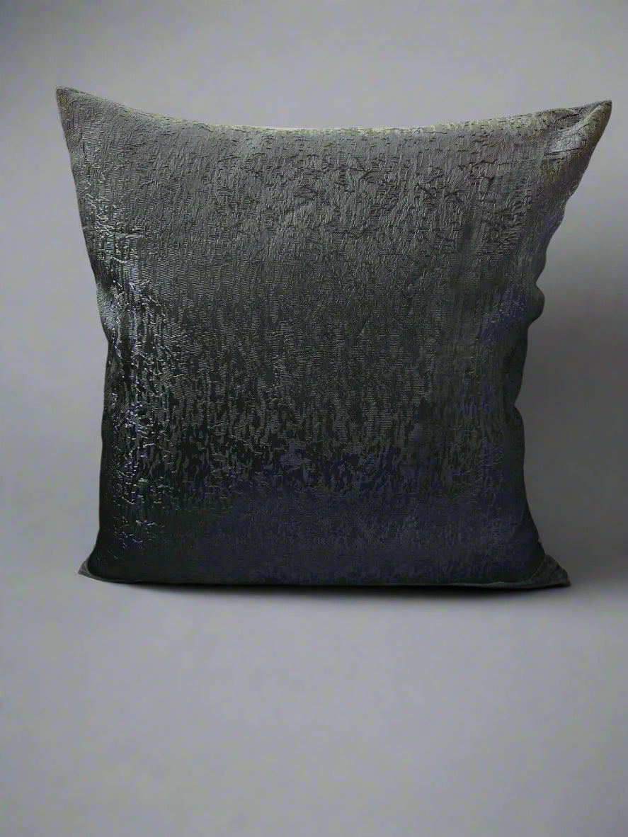 Textured black pillow on a beige floor