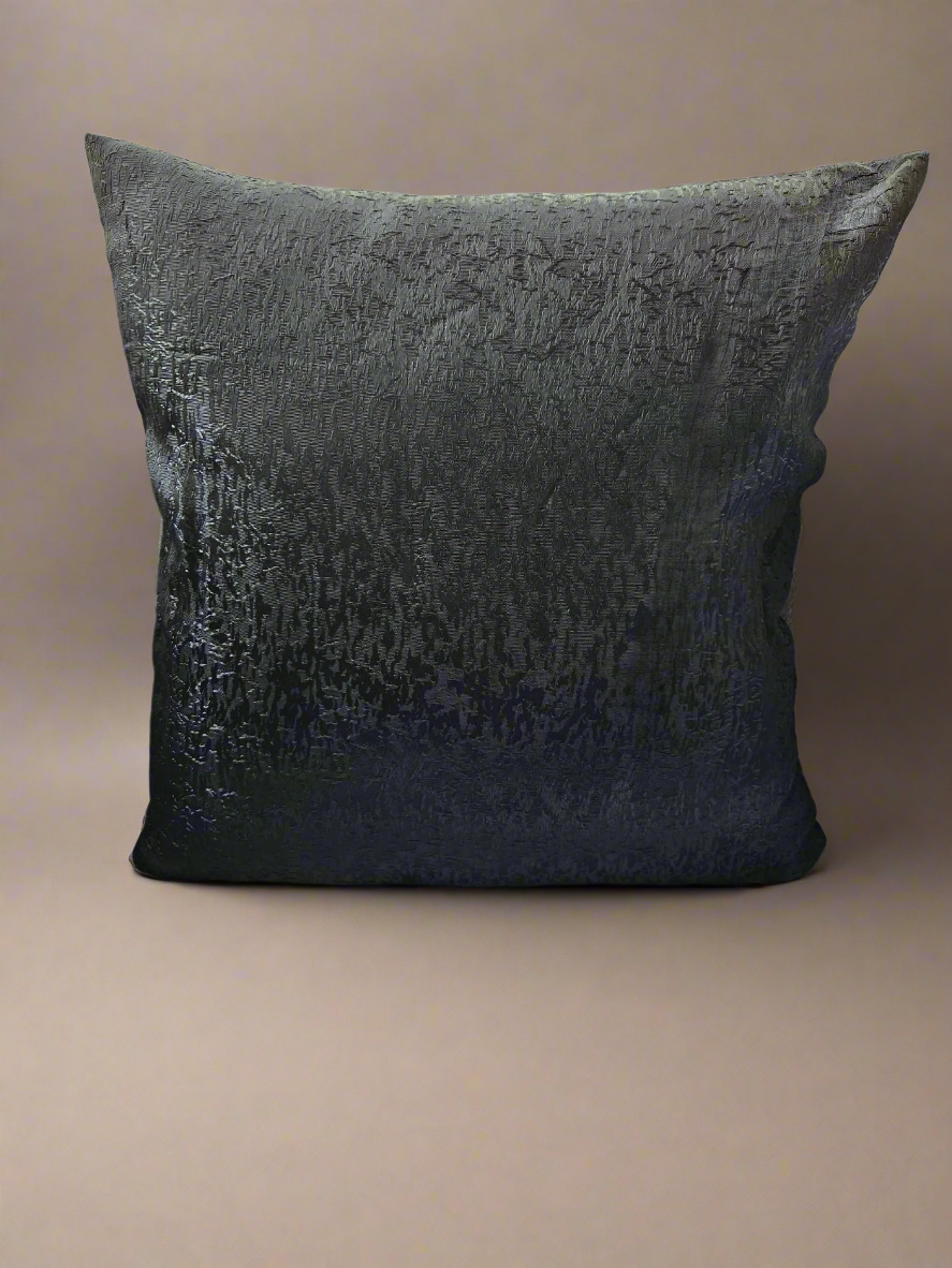 Textured black pillow on a beige background
